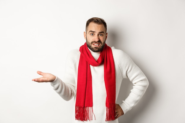 Clueless bearded man dont know, shrugging and saying sorry, standing puzzled against white background