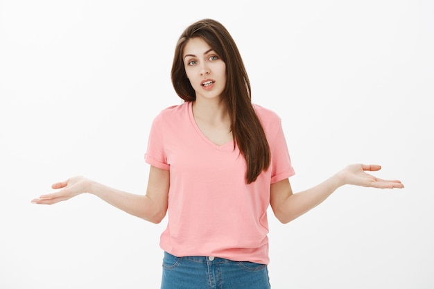 Clueless brunette woman posing in the studio