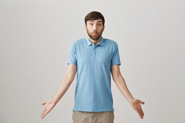 Clueless funny young bearded man posing