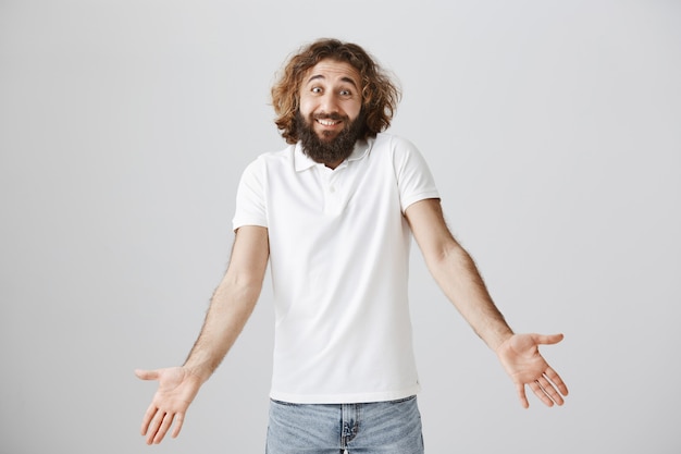 Free photo clueless handsome middle-eastern man with long beard, shrugging puzzled