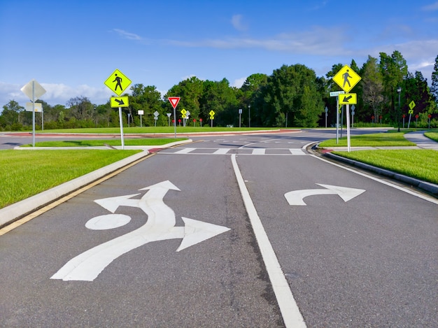 Cluster of street signs and road markings at an entrance to a loop