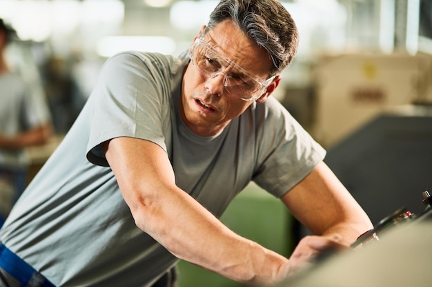 Free photo cnc machine operator feeling tired after working in industrial facility