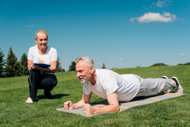 Coach measuring man's plank resistance