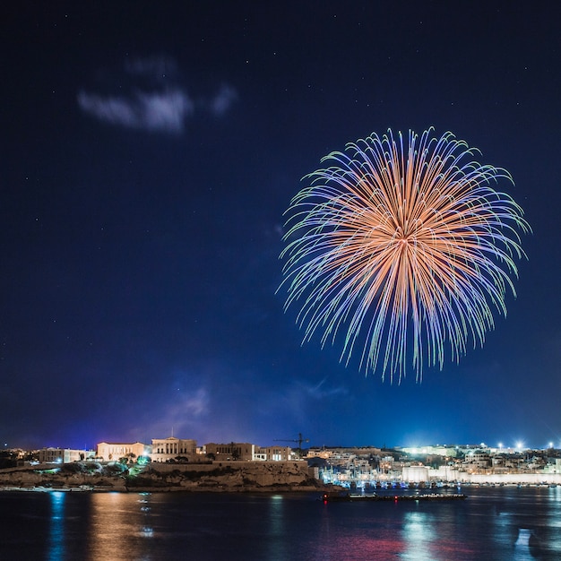 Foto gratuita città costiera con fuochi d'artificio