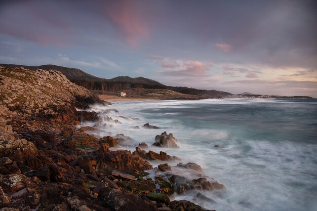 Coastline with stones on the shore during sunset