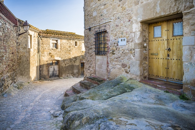 Cobblestone pathway surrounded with old buildings under a sunlight