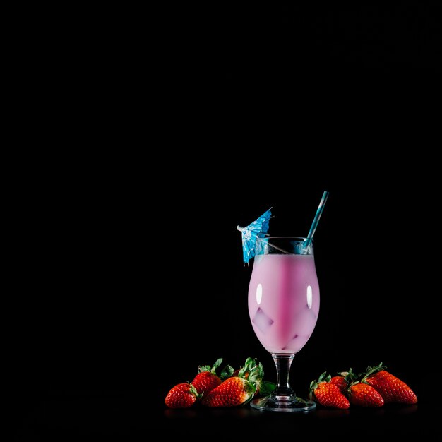 Cocktail and exotic fruits on black background with copyspace