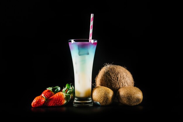 Cocktail and fruits on black background