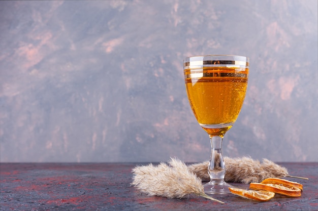 Бесплатное фото Бокал для коктейля со свежим соком и сушеными ломтиками лимона на мраморном фоне.