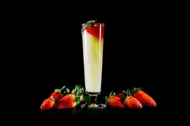 Cocktail and strawberries on black background