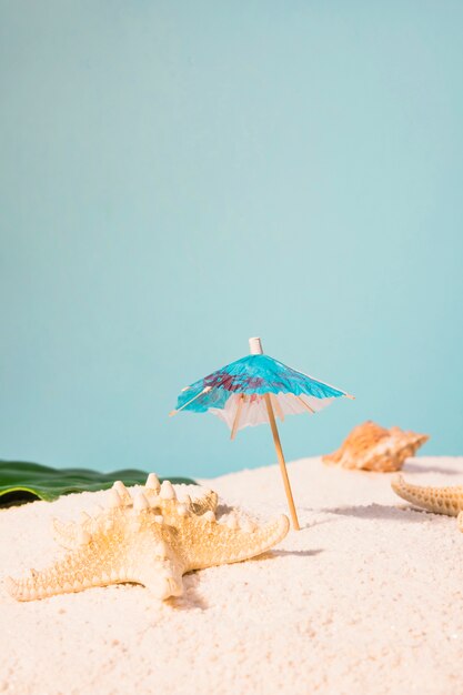 Cocktail umbrella and starfish on beach