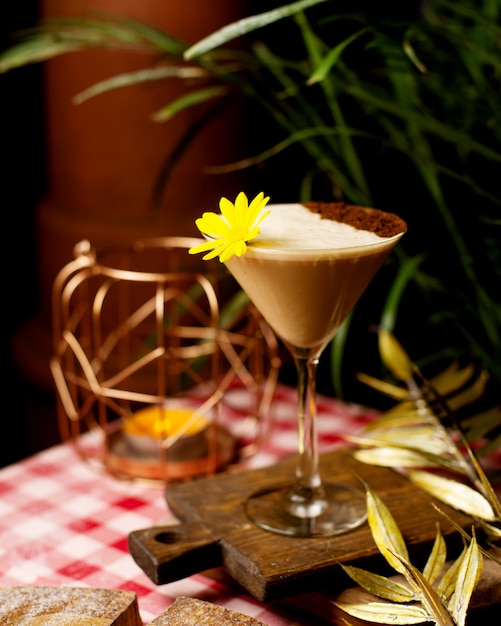 Cocktail con schiuma e polvere di cacao decorato con fiori