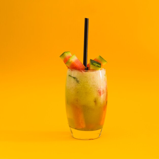 Cocktail with watermelon slice on yellow background