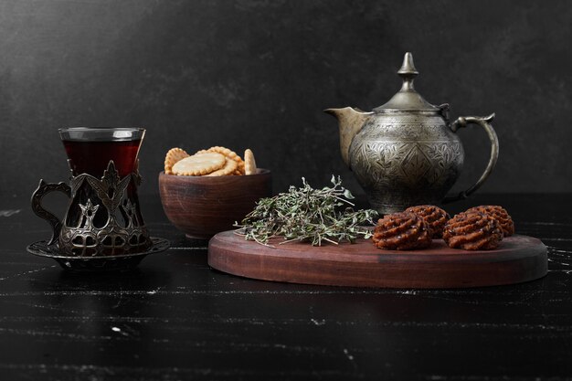 Cocoa and butter cookies on a wooden board with tea