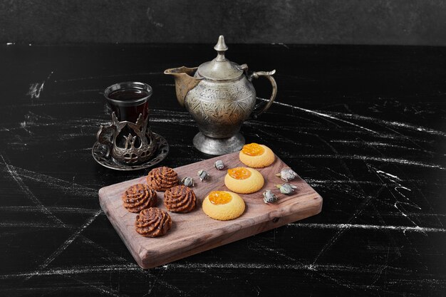 Cocoa and butter cookies on a wooden board with tea.