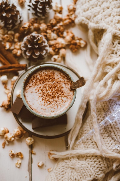 Free photo cocoa chocolate popcorn ginger biscuits and knitted blanket cozy winter home background