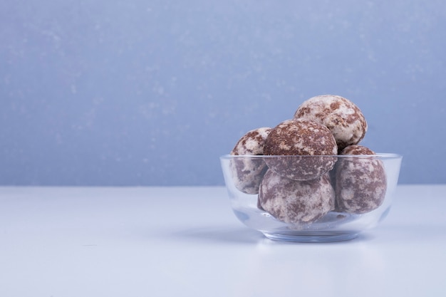 Cocoa gingerbreads in a glass cup on blue backdrop on the right side.