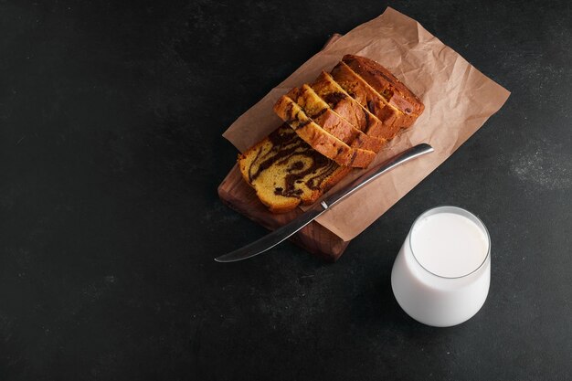 Cocoa pie slices on a wooden board with a glass of milk. 