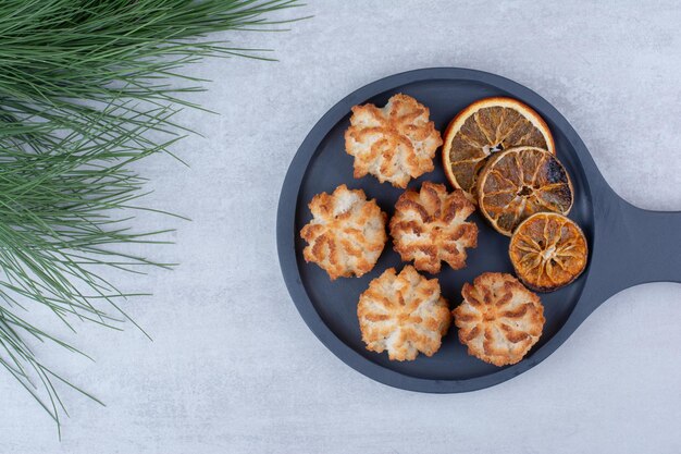 Coconut macaroons on dark board with orange slices. High quality photo