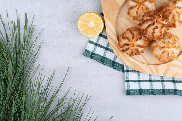 Coconut macaroons on wooden plate with half cut lemon. High quality photo