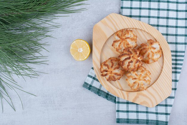 Coconut macaroons on wooden plate with half cut lemon. High quality photo