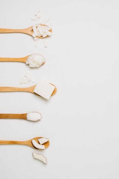 Coconut products in wooden spoons with copy-space