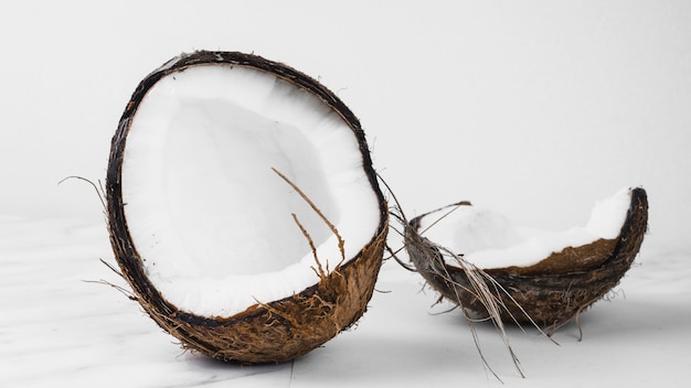 Coconut split into two halves against white background