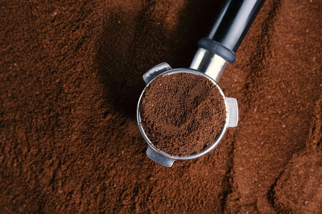 Coffee background. Coffee automatic from machine with ground coffee  on coffee background. Closeup.