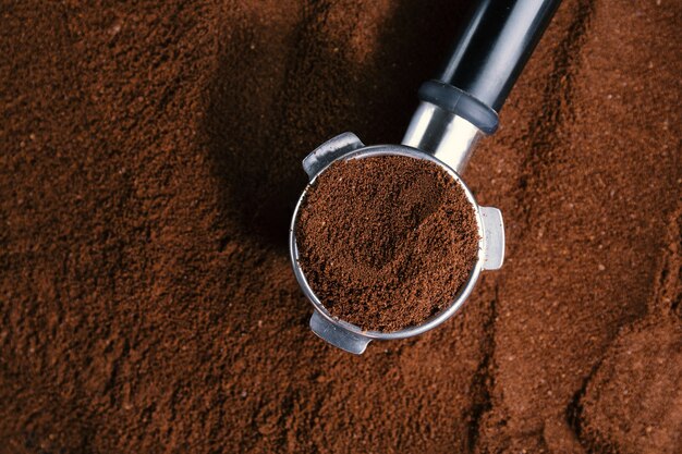 Coffee background. Coffee automatic from machine with ground coffee  on coffee background. Closeup.