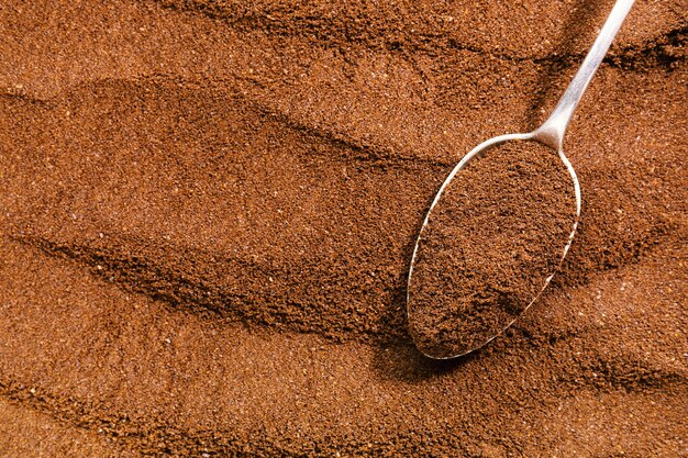 Coffee background. ground coffee in spoon  on coffee background.