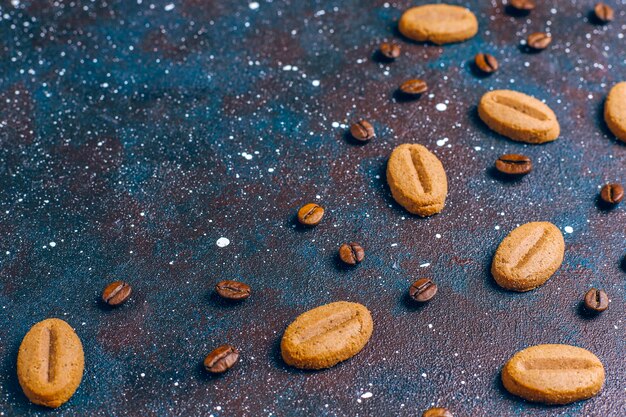 Печенье в форме кофейных зерен и кофейные зерна.