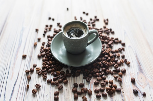 Coffee beans around cup with espresso