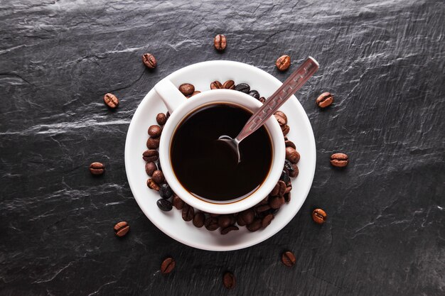 Coffee beans around cup