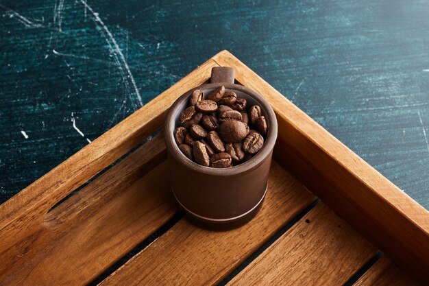 Coffee beans in a brown cup.