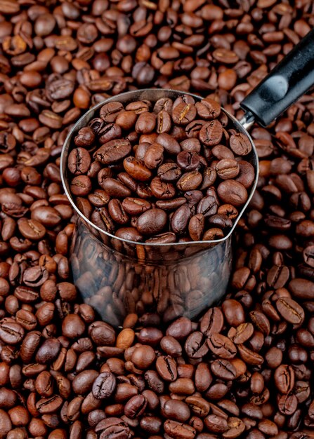 Coffee beans in a coffeepot or turk on coffee beans side view