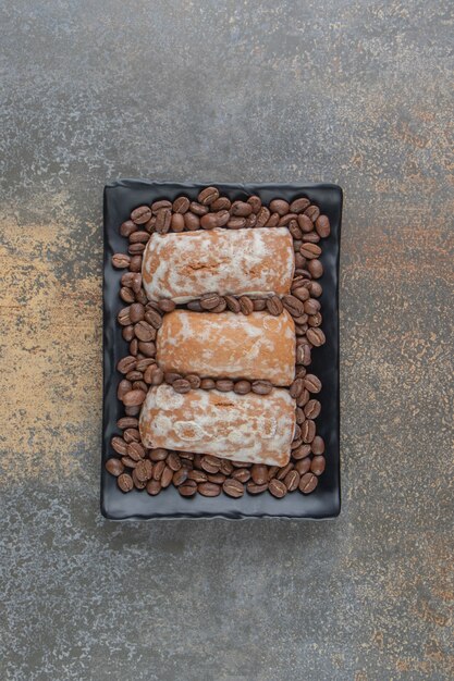 Coffee beans and cookies on a black platter 