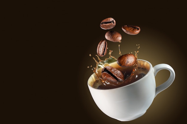 Coffee beans drop on splash coffee cup background