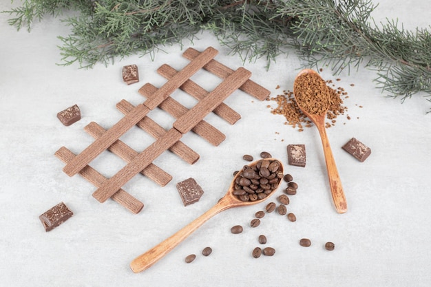 大理石の表面にコーヒー豆、挽いたコーヒー、ビスケット、チョコレート
