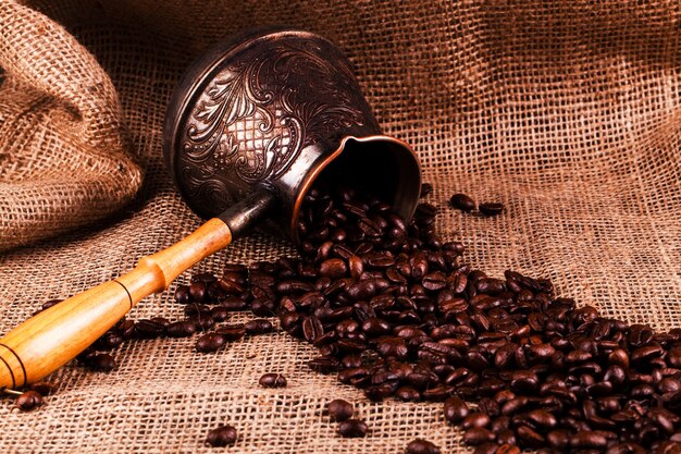 Coffee beans lie in cezve on the hessian