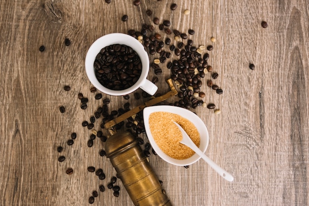 Кофе в зернах возле сахара и мясорубки