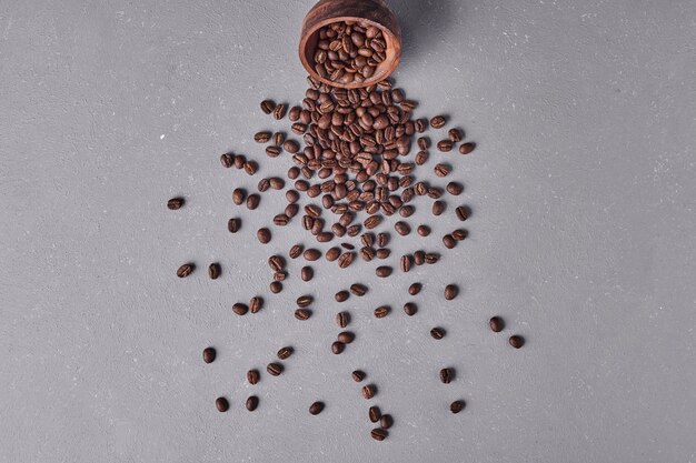 Coffee beans out of a wooden cup.