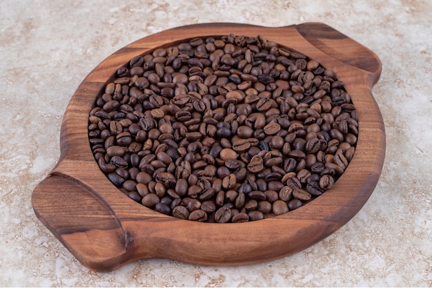 Coffee beans piled on a wooden tray 