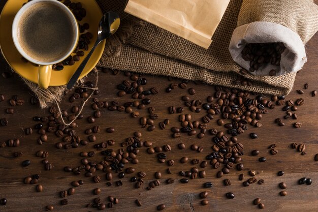 Coffee beans placed on desk with sack and cup