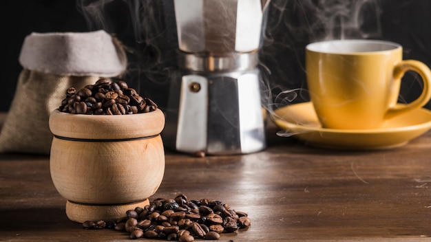 Coffee beans in pot near coffee set, sack and coffee maker