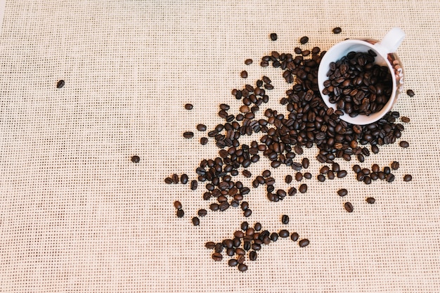 Coffee beans spilled from mug