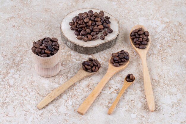 숟가락, 나무 조각 및 작은 컵에 커피 콩