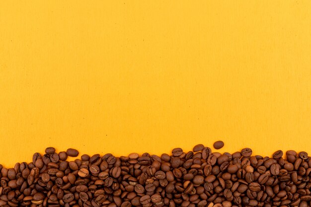 Coffee beans with copy space on yellow surface