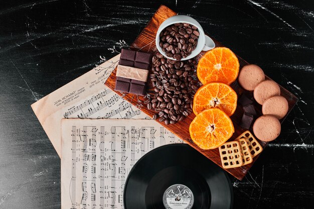 Coffee beans with orange slices and cookies.