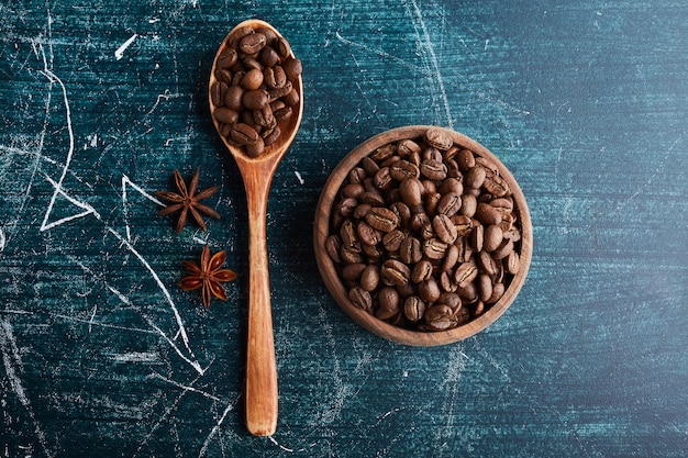 Coffee beans in a wooden cup and spoon. 