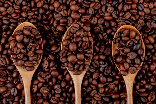 Кофе в зернах в деревянные ложки на вид сверху кофейных зерен